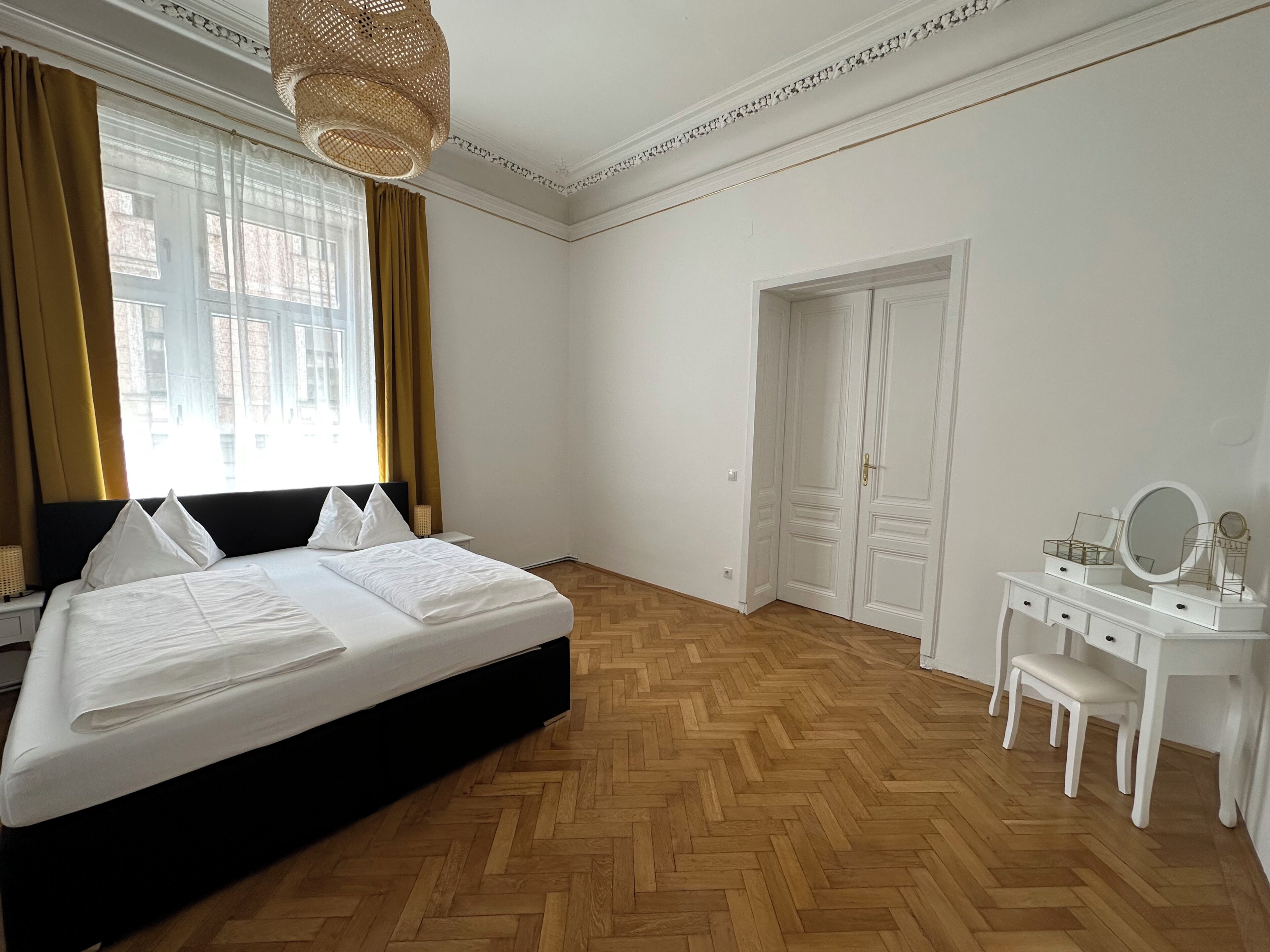 Ein Hotelzimmer mit einem großen Bett, einem Schminktisch mit Spiegel und einem Kleiderschrank.