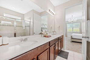 A modern bathroom with a large mirror, dual sinks, and a walk-in shower. - 5BR Pool Home, Near Disney, Orlando (Kissimmee)