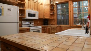 A kitchen with wooden cabinets, a white refrigerator, a microwave, and a sink.