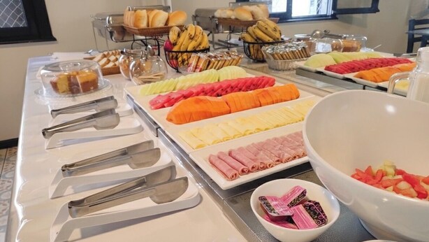 A buffet with various food items including fruits, pastries, and meats. - HOTEL SP CENTRO (São Paulo)
