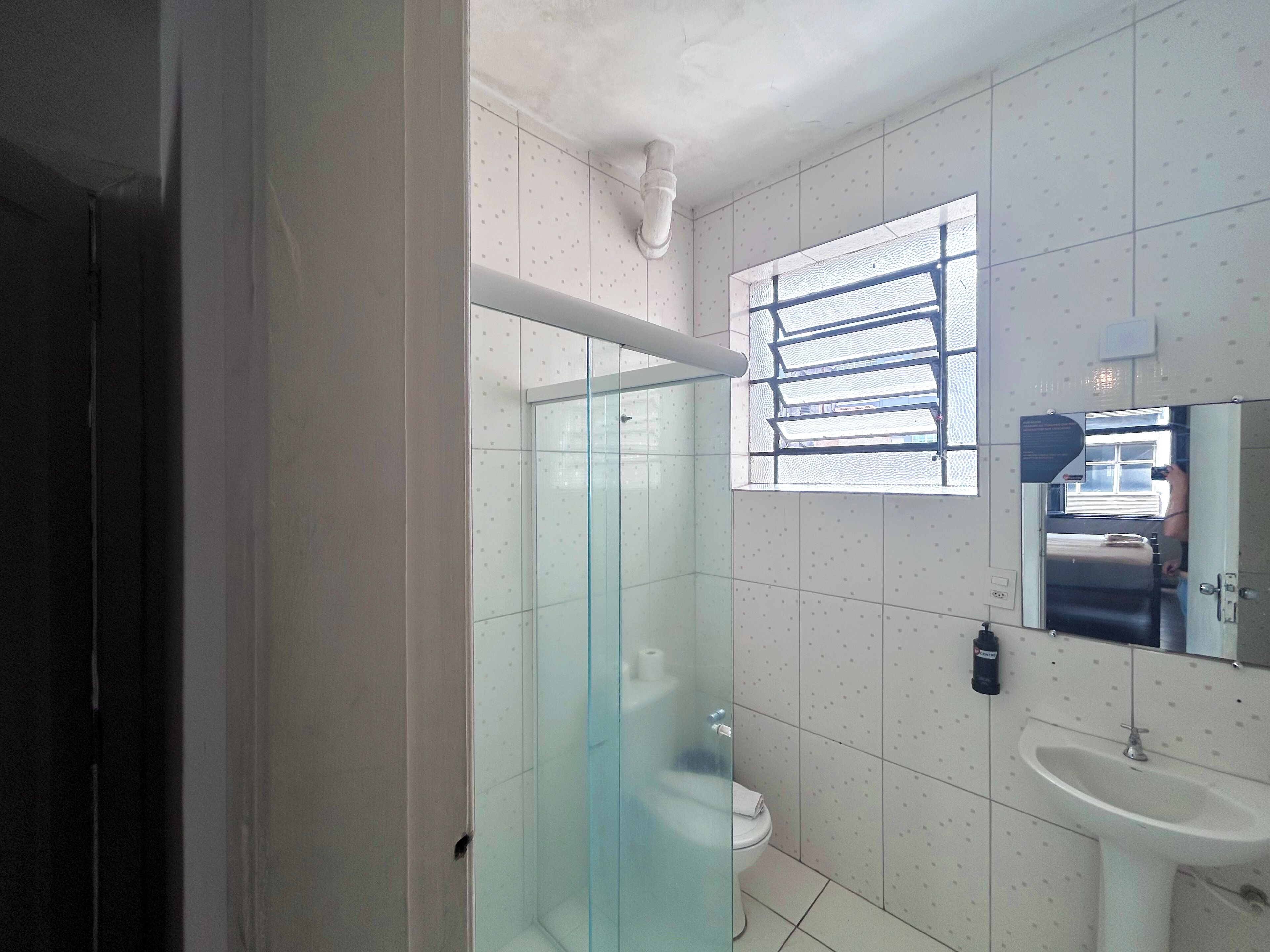 A modern bathroom with a glass shower enclosure, a toilet, and a sink.