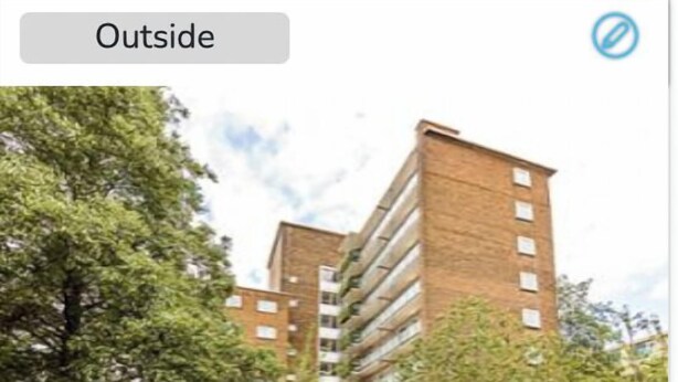 A modern multi-story building with a brick facade, surrounded by trees and parked cars. - Convenient 2BR/1BA Flat in Belgravia (London)