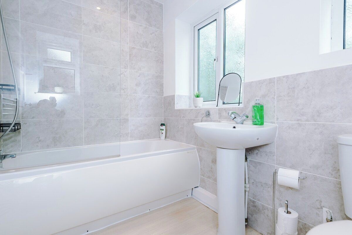 Un baño moderno con bañera, lavamanos y ventana.