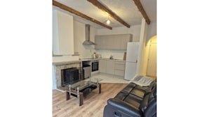 Una cocina moderna con armarios blancos, horno empotrado y una mesa de comedor de vidrio.