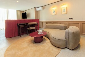 A modern living room with a red sofa, beige armchair, and a round coffee table. - Brada Collection Vendôme (Guadalajara)