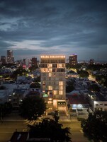 Un edificio moderno con un letrero llamativo que dice 'BRADA COLLECTION' en la parte superior.