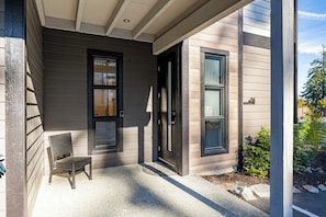 A residential building with a porch, a door, and a window.