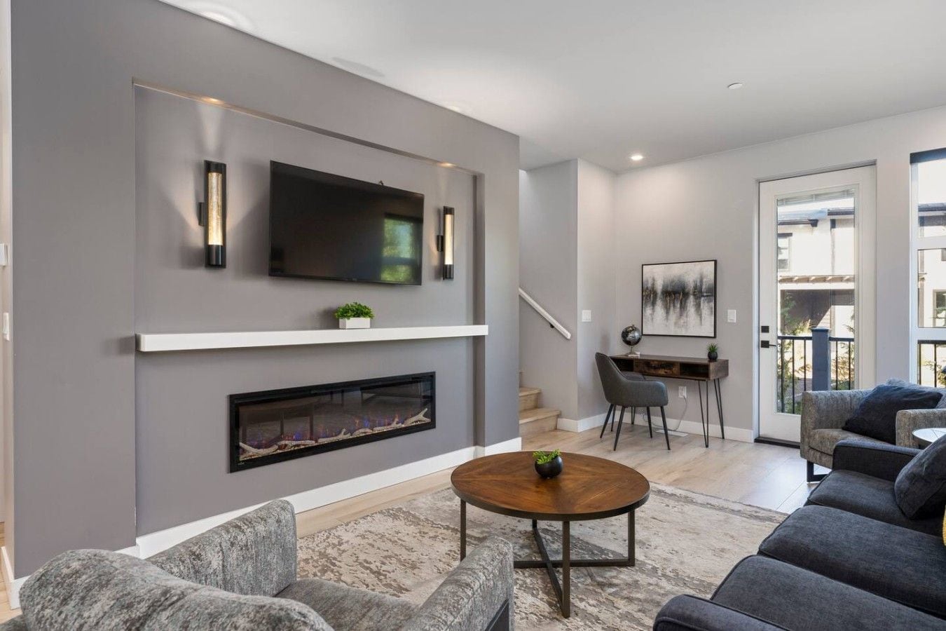A modern living room with a fireplace, a flat-screen TV, and a seating area with sofas and a coffee table.