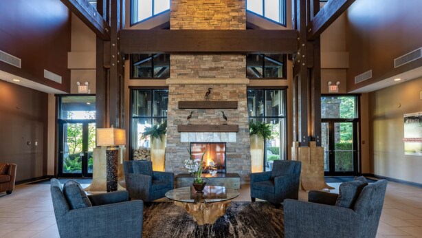 A spacious lobby with a stone fireplace, comfortable seating, and large windows. - Seaside 2 bdrm Townhome (Parksville)