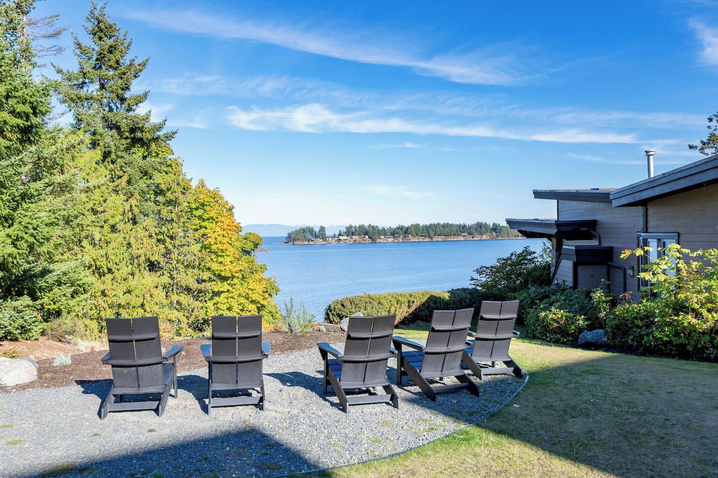 A modern house with a view of a lake and trees.