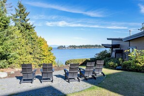 A modern house with a view of a lake and trees.