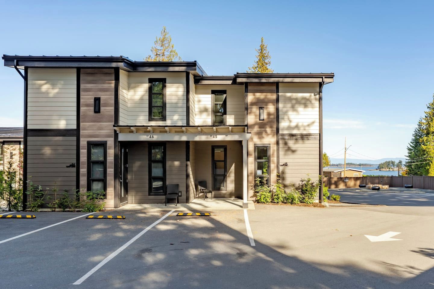 A two-story building with a parking lot in front.