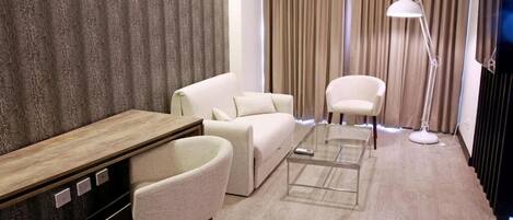 Una sala de estar moderna con sofá, sillón, mesa de centro y escritorio con lámpara.