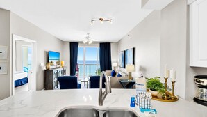 Une chambre d’hôtel moderne dotée d’une grande cuisine, d’un espace repas et d’un balcon avec vue.