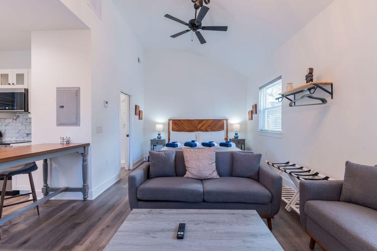 A modern living room with a sofa, a coffee table, and a ceiling fan.