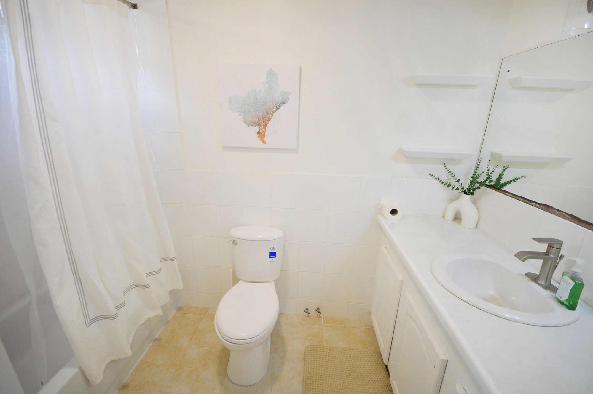 A bathroom with a toilet, sink, and shower.