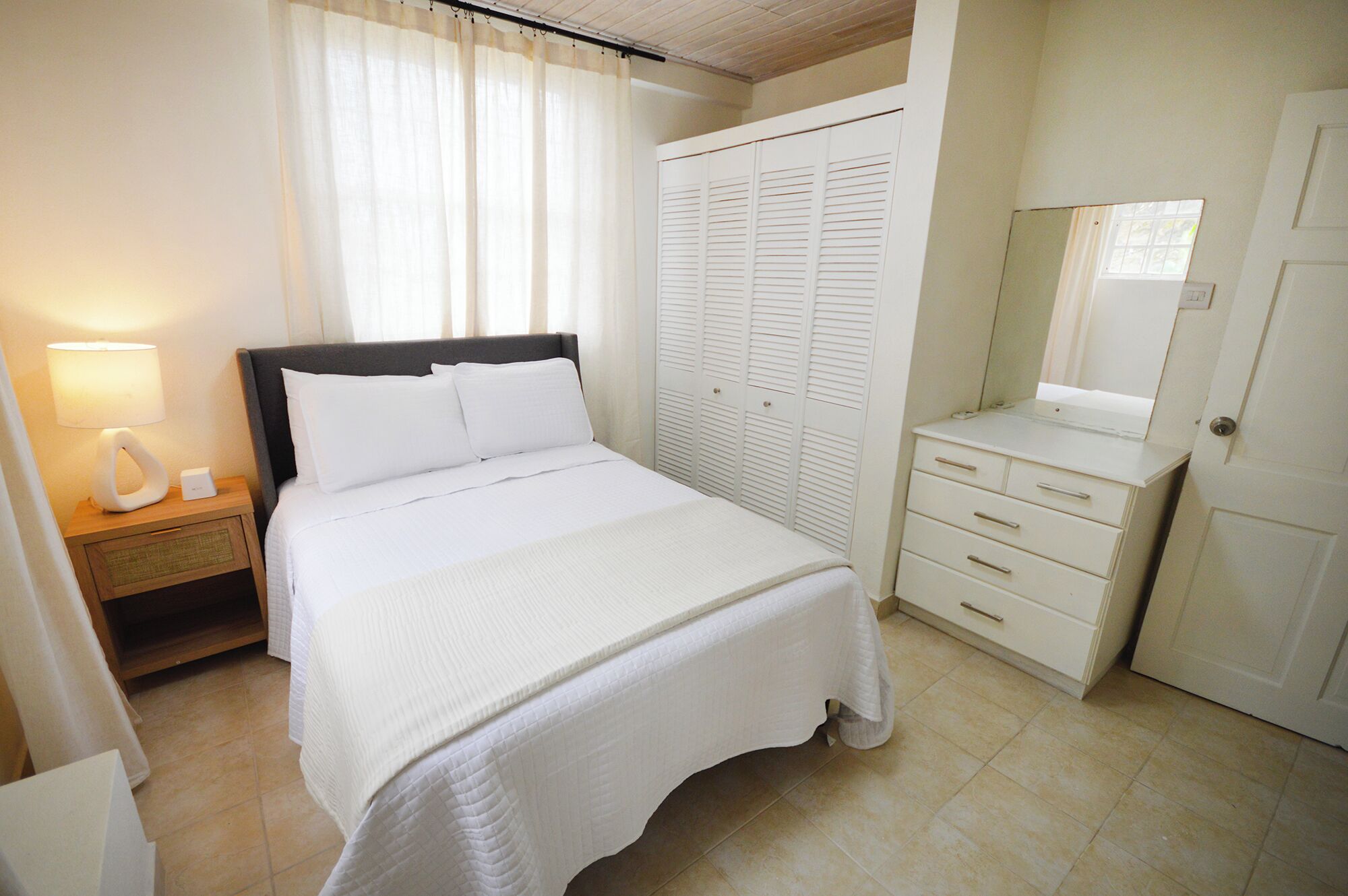 Une chambre à coucher comprenant un lit, une table de chevet, une armoire et une commode.