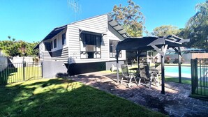 A house with a patio area, a pool, and a covered seating area. - Central Park - Rainbow Beach (Rainbow Beach)