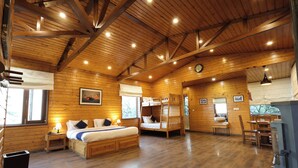 A wooden cabin interior with a large bed, a dining table, and a fireplace. - Sansa By The Woods - Manor Mussoorie (Mussoorie)