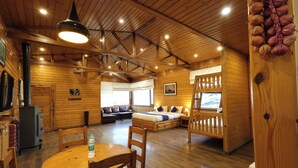 A wooden cabin interior with a dining area, a bed with a view, and a fireplace. - Sansa By The Woods - Manor Mussoorie (Mussoorie)