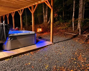 A hot tub under a wooden pergola in a forested area with a gravel path. - Brand new Ski Chalet 4 miles to Jay Peak (Jay)