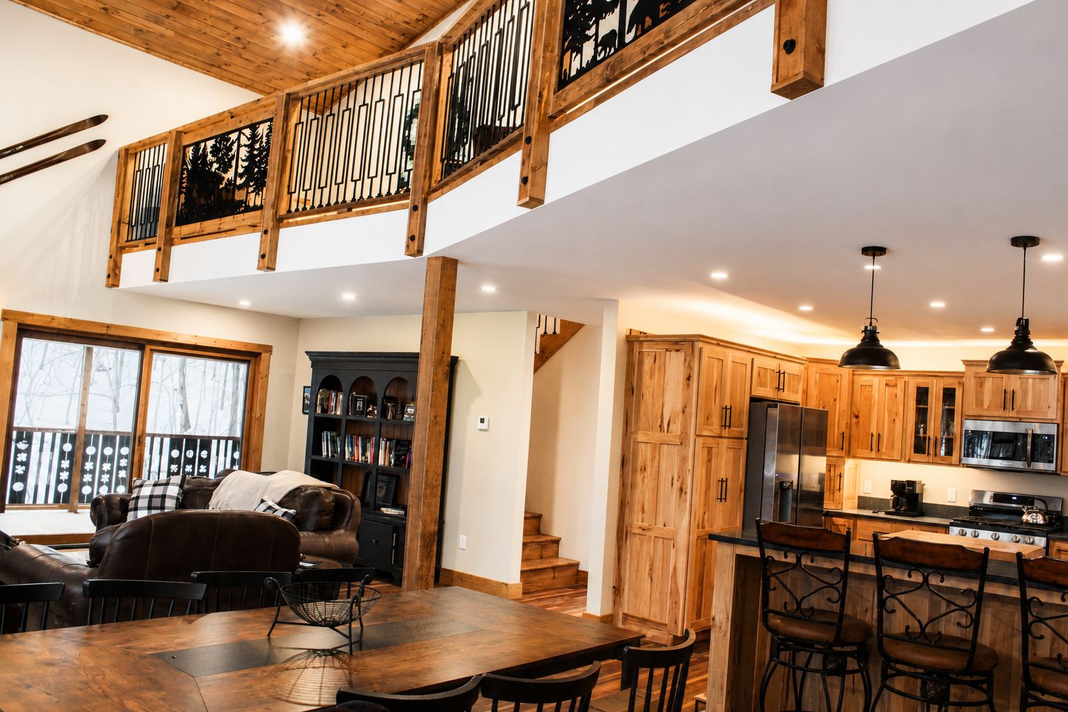 Eine geräumige Küche mit Holzausstattung, ein Essbereich mit großem Tisch und Stühlen sowie eine Treppe, die in ein Obergeschoss führt.