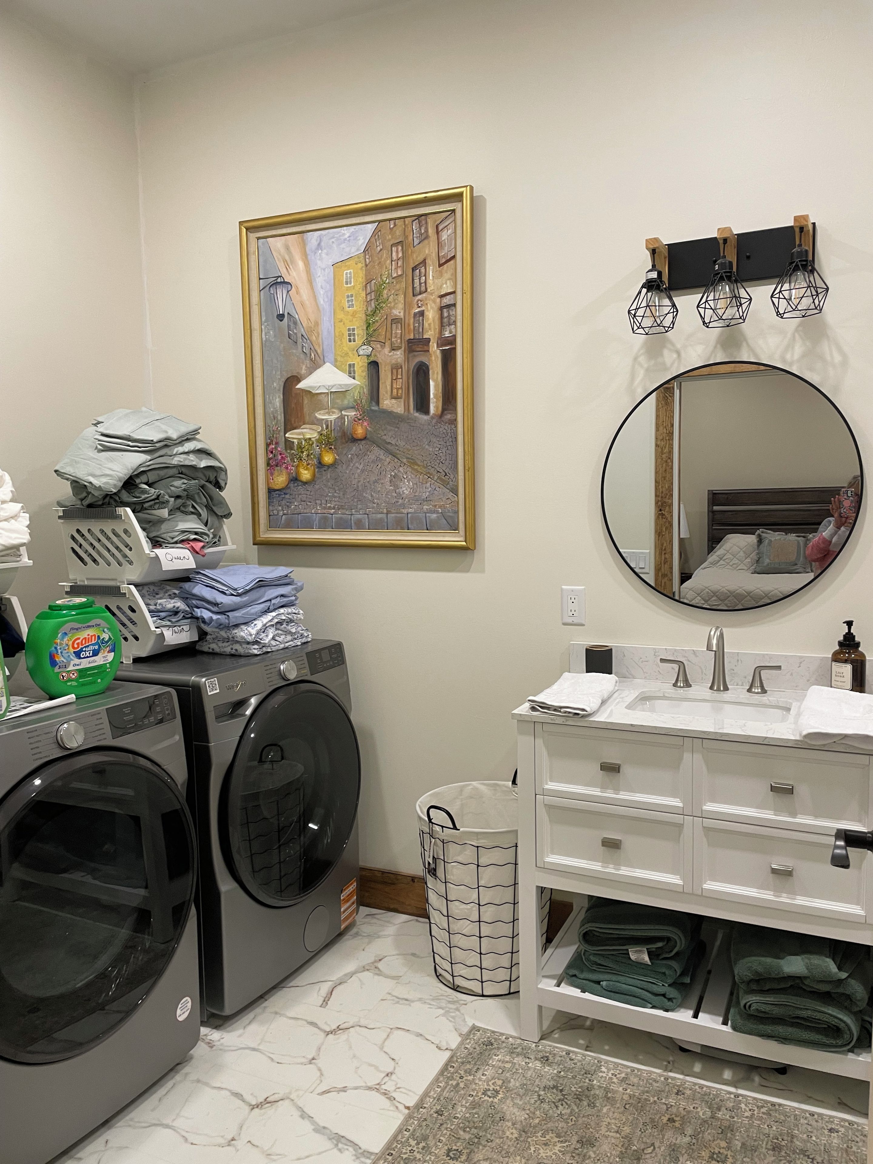 Un área de lavandería con lavadora, secadora y una pila de ropa doblada.