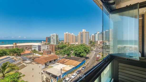 A high-rise building with a view of a cityscape, including tall buildings and a coastline.