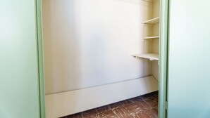Un armario con las puertas abiertas, mostrando estantes y espacio para colgar.