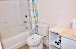 A bathroom with a bathtub, toilet, and a sink.