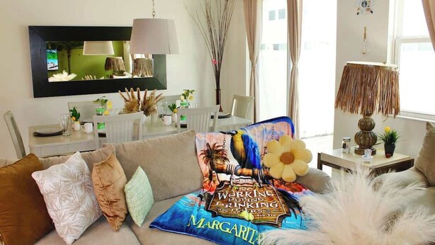 A living room with a sofa, a coffee table, a TV, and a lamp.