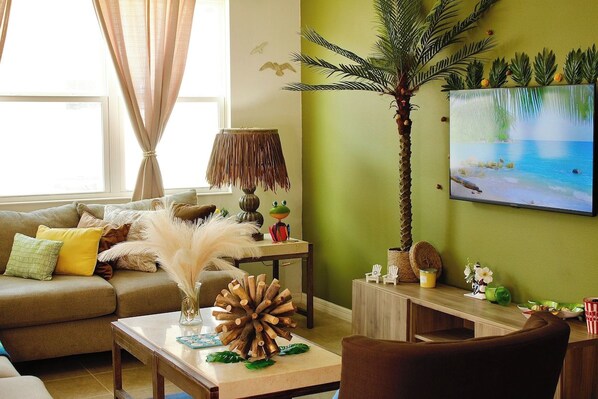 A living room with a sofa, a coffee table, a lamp, and a painting on the wall.