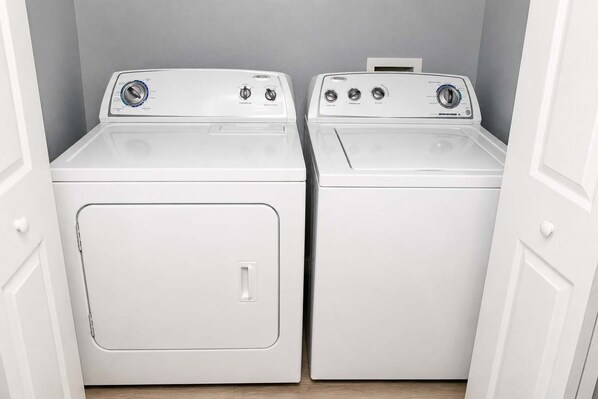 A laundry room with two white front-loading washing machines.