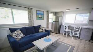 Ein kompakter Wohnbereich mit Sofa, Esstisch und Küchenzeile.