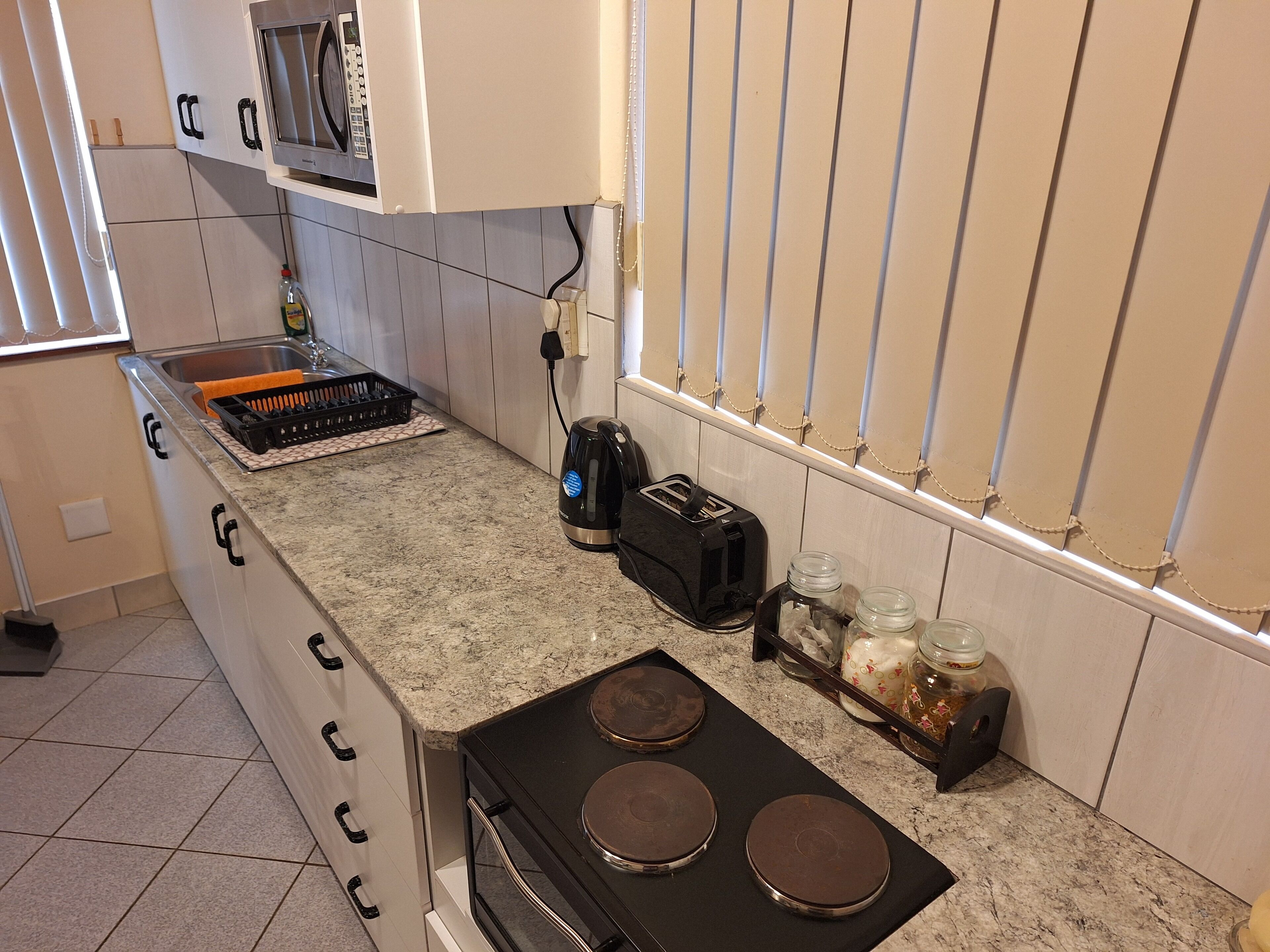 Een keuken met een fornuis, broodrooster en kastjes.