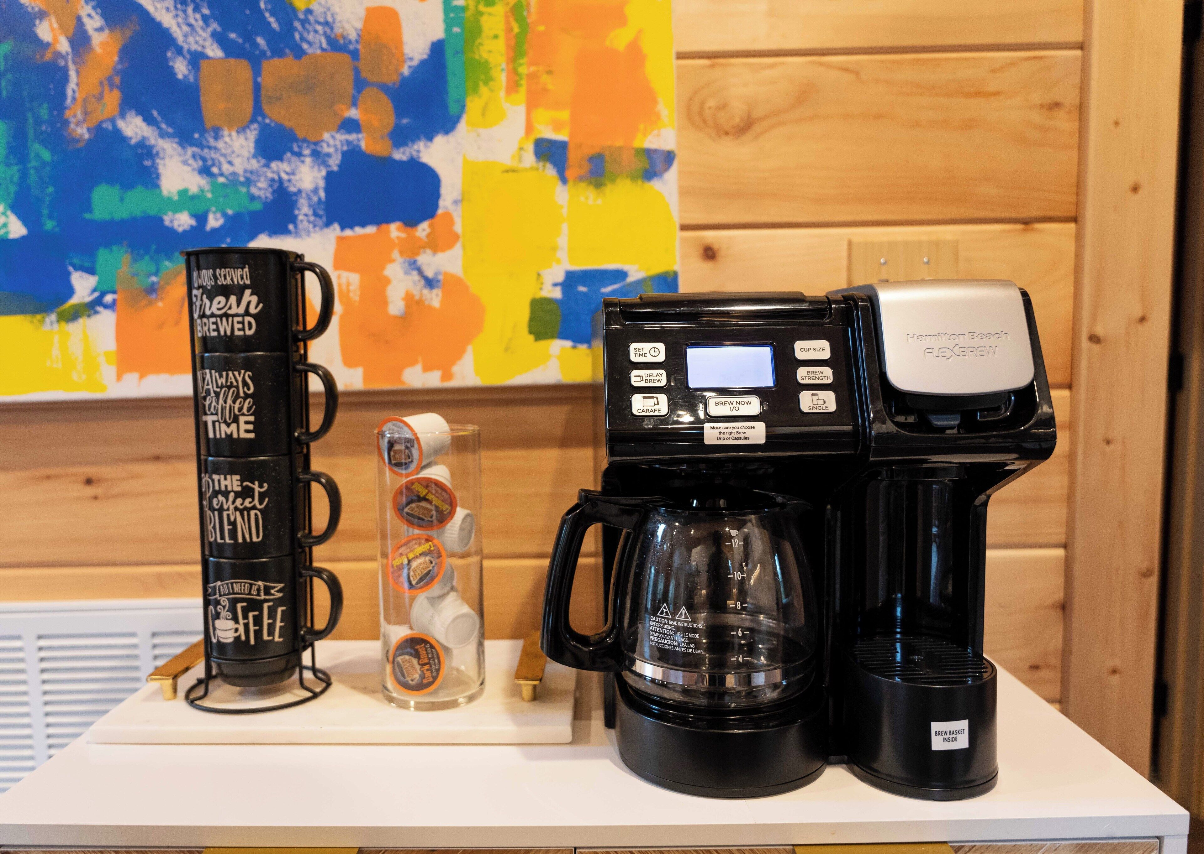En kaffebryggare med en digital display och en kaffekanna placerad på en vit bänkskiva.