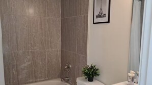 A bathroom with a bathtub, toilet, and sink. - Entire basement, close to CTrain (Calgary)
