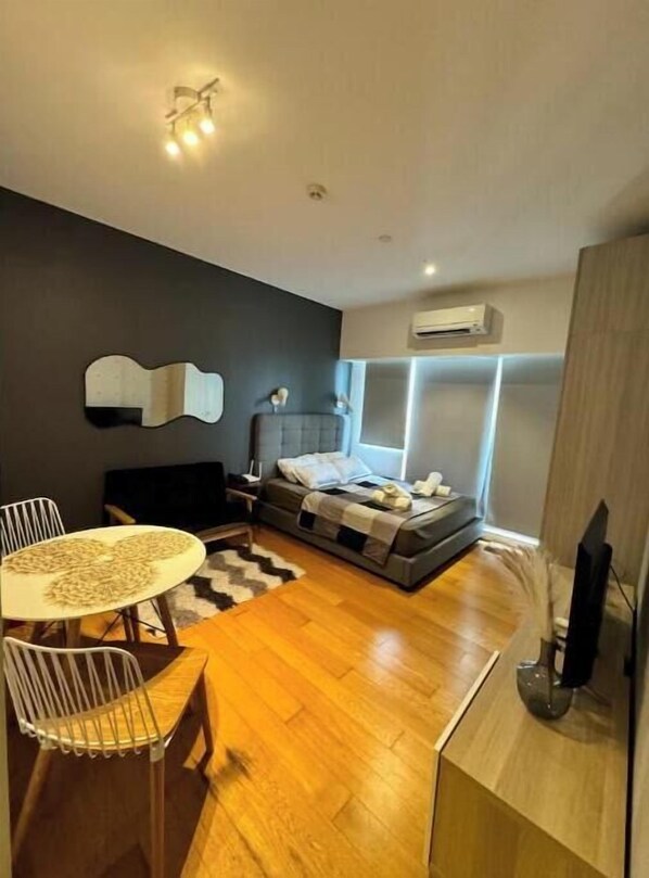 Um quarto moderno com cama, mesas de cabeceira, escrivaninha e uma cadeira.