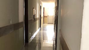A long, narrow hallway with a tiled floor and a plain wall. - Pousada Toco do Mar (Fortaleza)