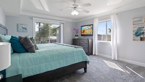 A bedroom with a bed, a ceiling fan, a TV, and a window. - Lake View Condo - Heart of Osage Beach + Boat Slip (Osage Beach)