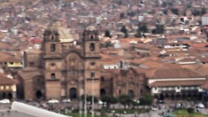 A drink with a straw and fruit garnish on a table with a view of a cityscape in the background. - CUSCO VISTA GUETS HOUSE (Cusco)