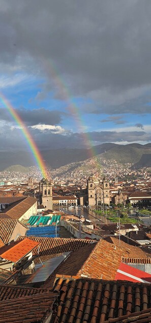 A cityscape with a prominent church and a rainbow. - CUSCO VISTA GUETS HOUSE (Cusco)