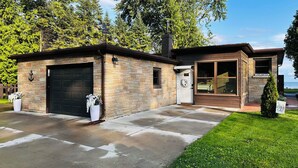 A two-story building with a garage, a covered porch, and a view of the lake.