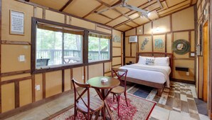 Una habitación tipo cabaña con cama, mesa de comedor y sillas.