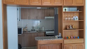 A kitchen with wooden cabinets, a gas stove, a microwave, and a sink.