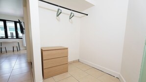 A room with a wooden dresser, a black ceiling track, and a white wall. - Sunny Seaside Getaway (San Juan)