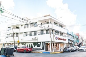 Un immeuble à plusieurs étages dont le rez-de-chaussée est aménagé en espace commercial, notamment avec un magasin Rent-A-Center.