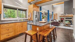 A modern kitchen with wooden cabinets, a granite countertop, and a central island with stools.