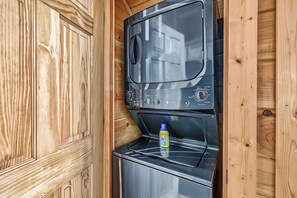 Eine kompakte, moderne Küche mit integriertem Waschmaschine und Trockner, ausgestattet mit Holzvertäfelung.