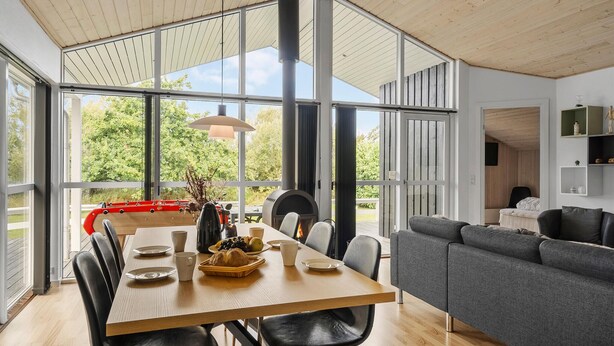 Ein moderner Essbereich mit einem Holztisch, schwarzen Stühlen und einem grauen Sofa.